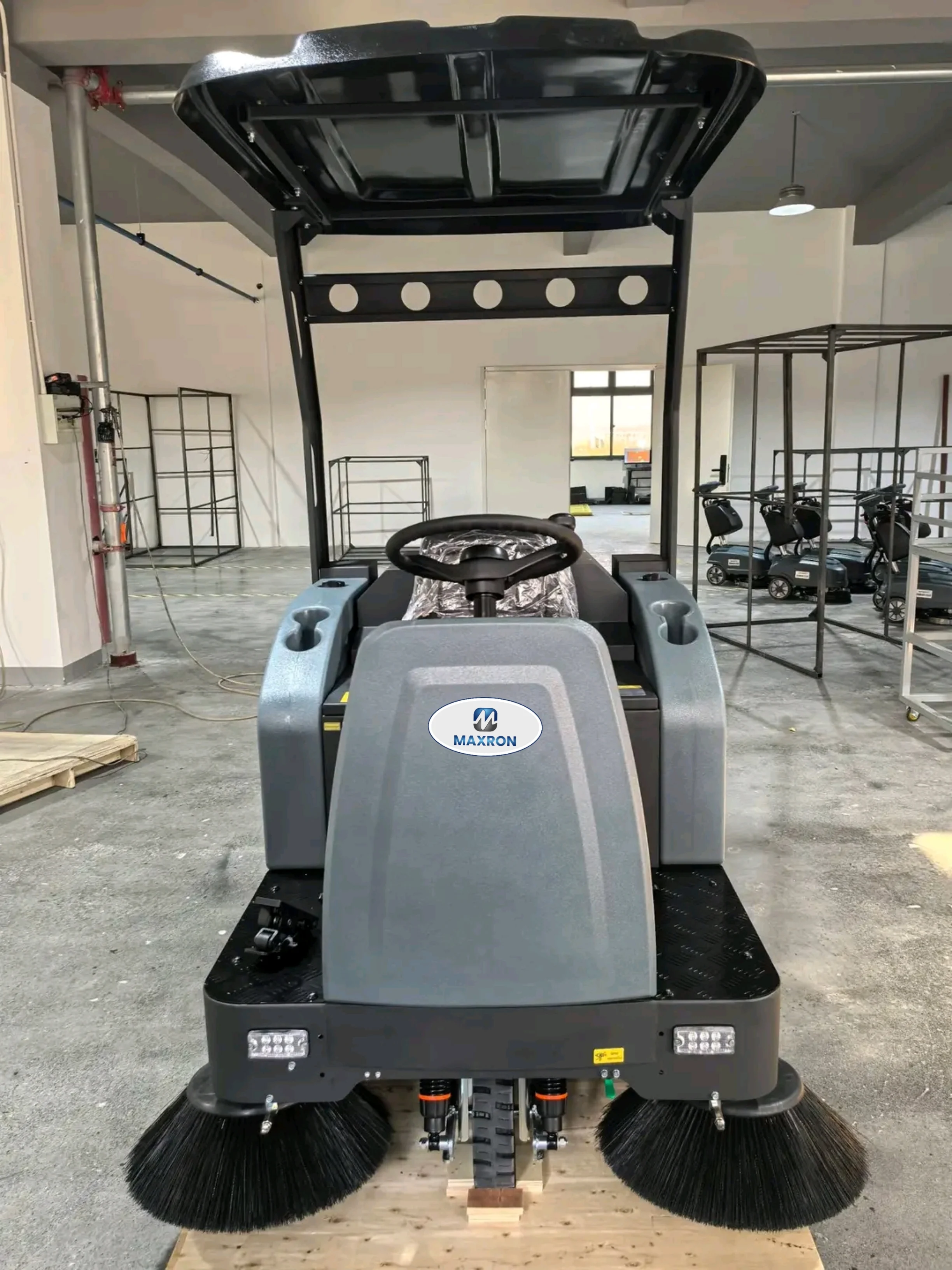 Maxron ride-on floor sweeper displayed in warehouse showroom India